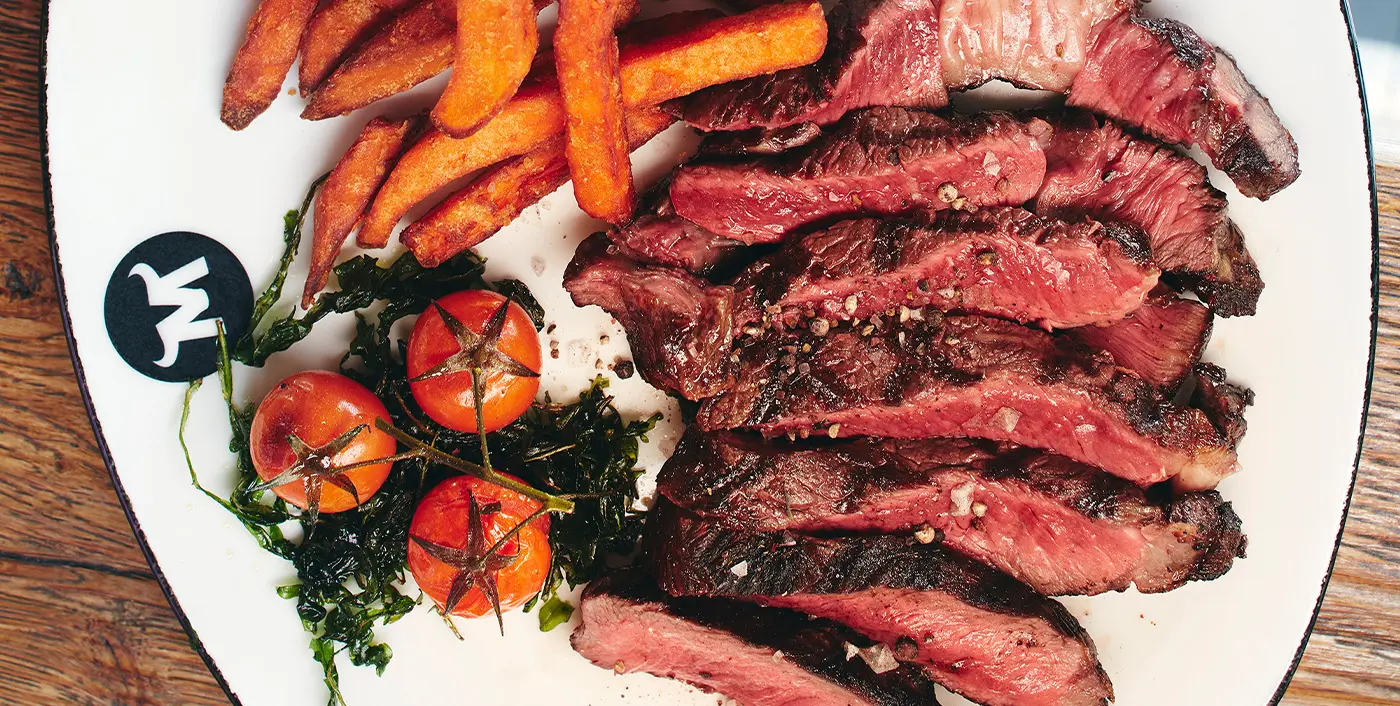 Der Teller ist angerichtet mit einem saftigen Steak und knusprigen Pommes